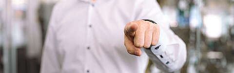 Mitarbeiter von OCTO IT zeigt mit einem Finger auf die betrachtende Person