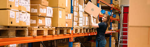 Mitarbeiterin der OCTO IT holt ein Dell-Paket aus dem Lager