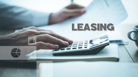 IT-Hardware-Leasing Nahaufnahme einer Person, die einen Taschenrechner mit Finanzunterlagen auf einem Schreibtisch benutzt. Das Wort "LEASING" ist in fetten Buchstaben quer über das Bild zu lesen. Eine Kaffeetasse und Tabellen sind im Hintergrund schwach zu erkennen.