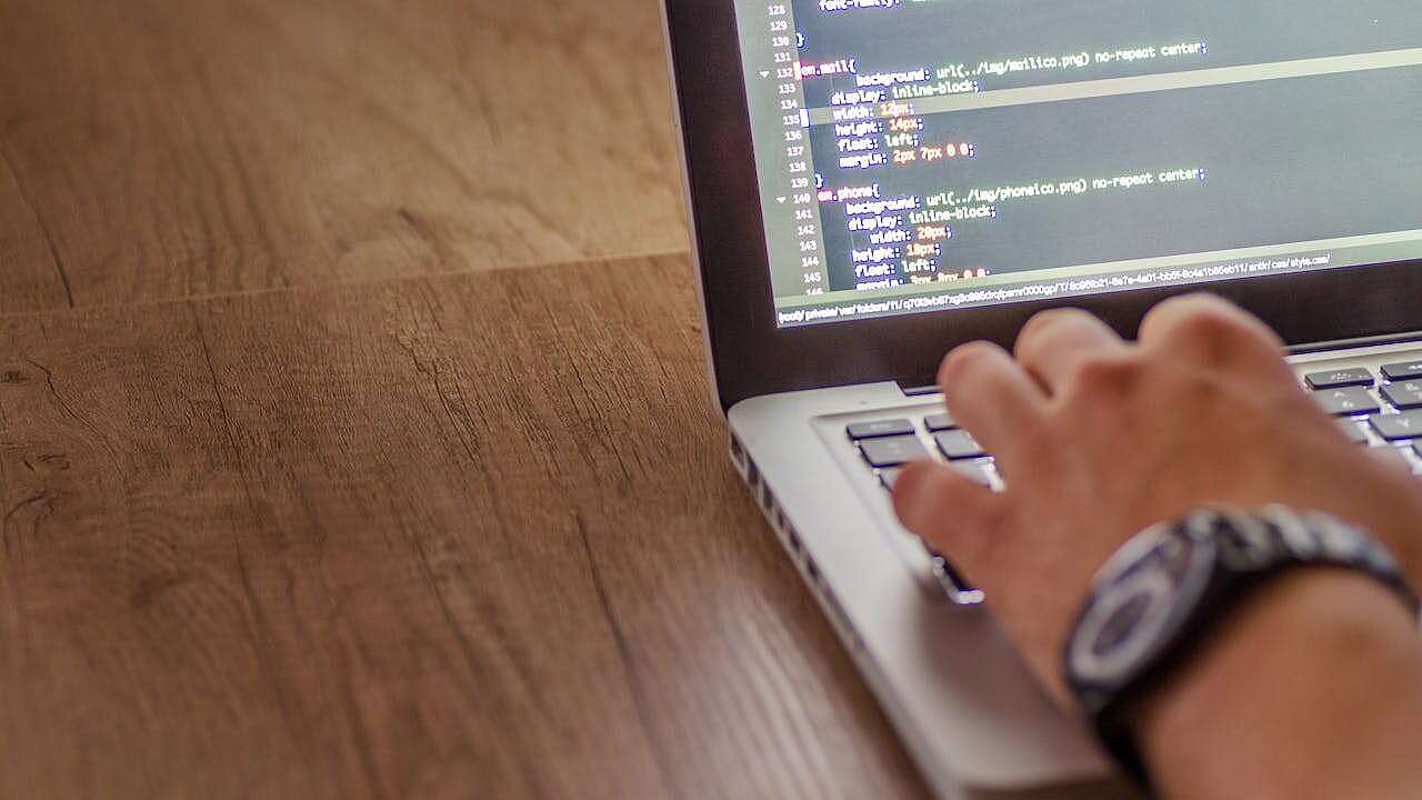 Entlastung der IT-Abteilung durch CPO Ein IT-Mitarbeiter schreibt Code an seinem Notebook