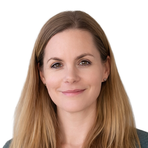 Eine Frau mit langem, glattem blondem Haar und heller Haut lächelt sanft in die Kamera. Sie trägt ein graues Oberteil und hat einen neutralen Hintergrund hinter sich.